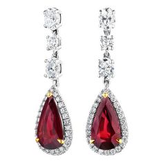 Two natural pear-shaped vivid red rubies. These gemstones are halo'd by round brilliant-cut diamonds and dangle from oval diamonds. The rubies are cradled in yellow gold prongs. These earrings are 18KT white gold and total weight is 7.44 carats. Red Diamond Teardrop Earrings, Red Halo Setting Earrings For Wedding, Red Teardrop Jewelry With Diamond Accents, Red Ruby Pear-shaped Earrings, Red Pear-shaped Cubic Zirconia Earrings, Diamonds Direct, Diamond Dangle Earrings, Ruby Diamond, Gorgeous Jewelry