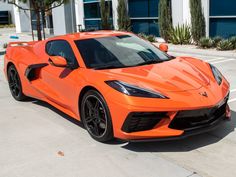 an orange sports car parked in a parking lot