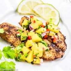 grilled chicken with pineapple salsa and cilantro garnish on a white plate