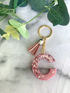 a keychain with a tassel hanging from it's side on a marble surface