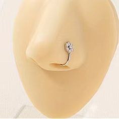 a white diamond ring sitting on top of a mannequin head