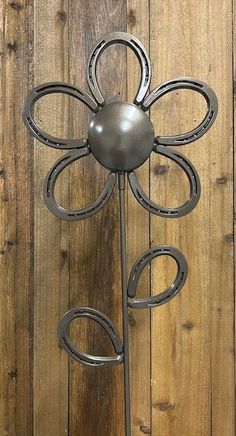 a metal flower on a wooden wall