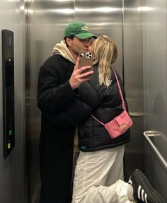 a man and woman are kissing in an elevator