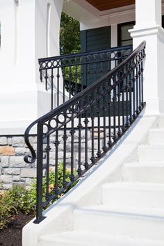 an iron stair railing on a white house