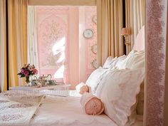 a bedroom with pink walls and white bedding