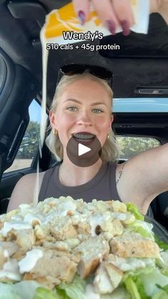 a woman sitting in the back seat of a car with food on top of it