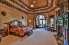 a large bedroom with an ornate ceiling and fireplace