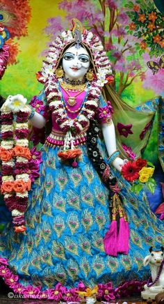 an idol is displayed in front of a colorful wall with flowers and other decorations on it