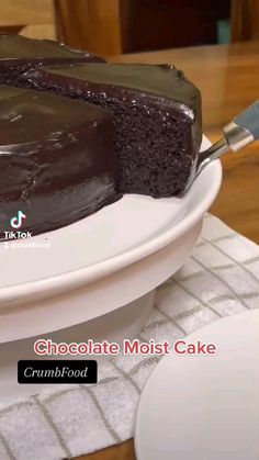 a chocolate cake sitting on top of a white plate with a spatula in it