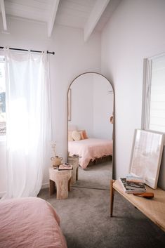 a bedroom with two beds and a mirror