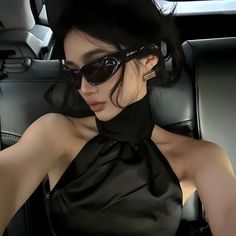 a woman wearing sunglasses sitting in a car