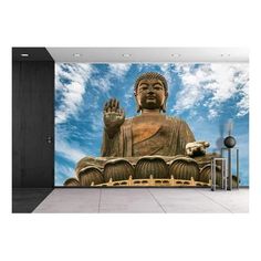 a large buddha statue sitting in the middle of a room with blue sky and clouds behind it