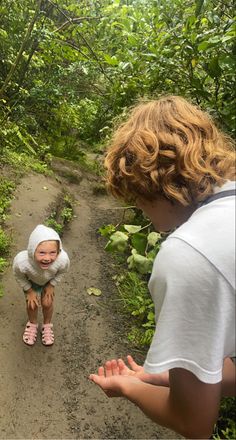 a baby sitting on top of a wooden bench in the woods