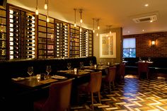 an empty restaurant with wine bottles on the wall