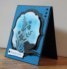 a blue card with flowers on it and a thank you tag attached to the front