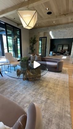 a living room filled with furniture and large windows