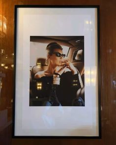 a framed photograph of a woman sitting in a car