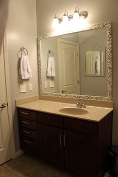 a bathroom with a sink, mirror and towel rack