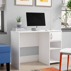 a white desk with a computer on top of it in front of a blue chair