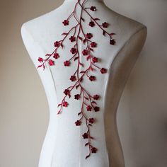 a white mannequin with red flowers on it's back and neckline