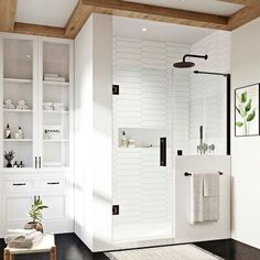 a bathroom with white walls and black flooring has a glass shower door in the center