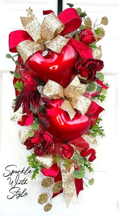 a red heart wreath with gold bow and roses