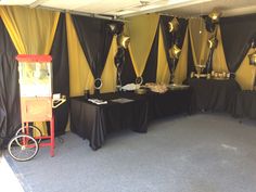 a room with black and yellow decorations on the wall next to a table filled with food