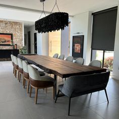 a dining room table with chairs and a chandelier hanging from the ceiling