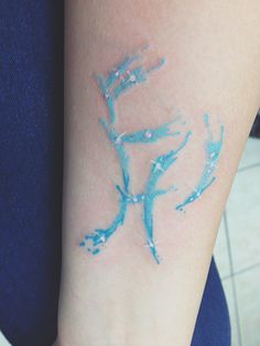 a woman's arm with blue paint on it and the word love written in white ink