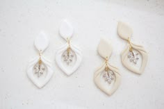 three pairs of white and gold earrings