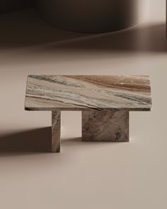 a marble bench sitting on top of a floor next to a round object in the background