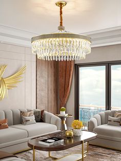 a living room filled with furniture and a chandelier hanging over the top of it