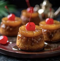 mini pineapple upside down cakes on a plate with cherries around the edges and one topped with a cherry