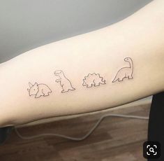 a woman's arm with three small dinosaurs on the left side of her arm