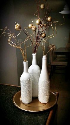 two white vases with gold ornaments in them