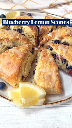 blueberry lemon scones on a white plate with sliced lemons and some blueberries