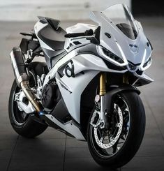 a white motorcycle parked on top of a tiled floor