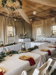 a table set up with white linens and red napkins for christmas dinner party