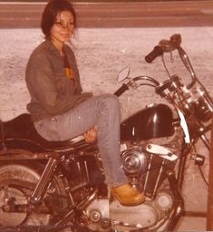 a woman sitting on top of a motorcycle