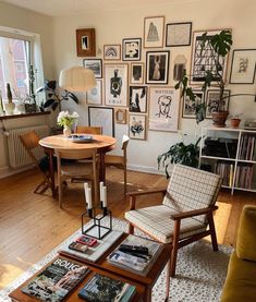 a living room filled with furniture and lots of framed pictures on the wall next to a coffee table