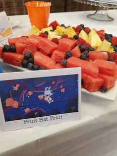 watermelon slices and blueberries are arranged on a platter at a fruit bar