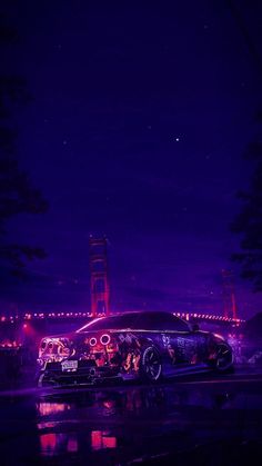 a car parked in front of a bridge at night with lights on it's side