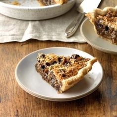 a piece of pie sitting on top of a white plate next to a bowl filled with fruit