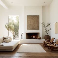 a living room with white furniture and a fireplace