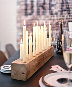 candles are lit on a table with plates and wine glasses