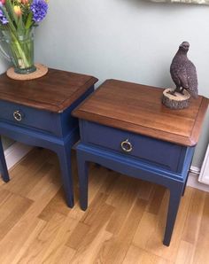 two blue nightstands with flowers on top of them and a bird figurine