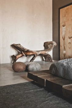 a bed sitting next to a wooden bench on top of a rug in a bedroom