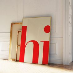 two framed art pieces sitting on the floor in front of a wall with white and red designs