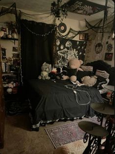 there is a bed with many stuffed animals on it in this room, and the curtains are black