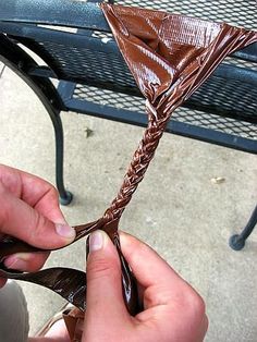 a person is holding a piece of chocolate in their hand while sitting on a bench